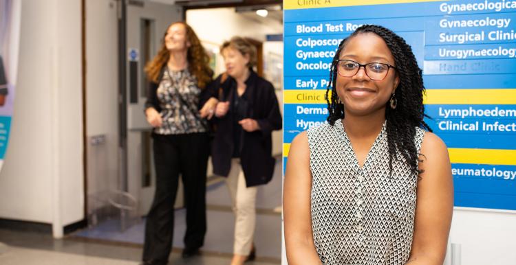 A woman standing infront of a sign in a hospital A woman standing infront of a sign in a hospital