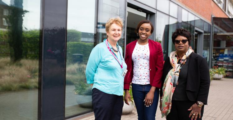 Three women outside hospital entrance Three women outside hospital entrance