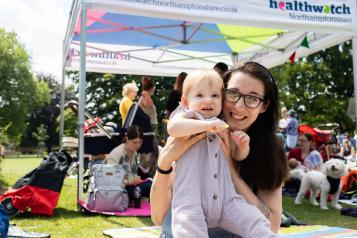 Woman sitting on a picnic blanket with her baby