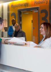 Woman speaking to someone at the hospital reception